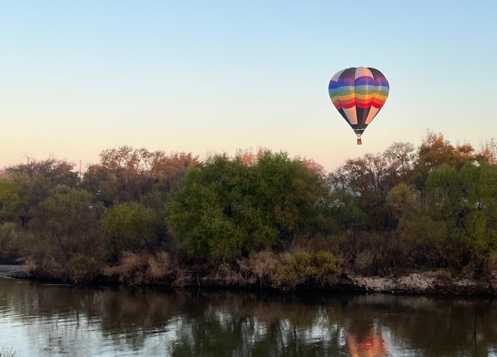 A hot air balloon above the wooded banks of the Arkansas River at Wichita, Sedgwick County, Kansas