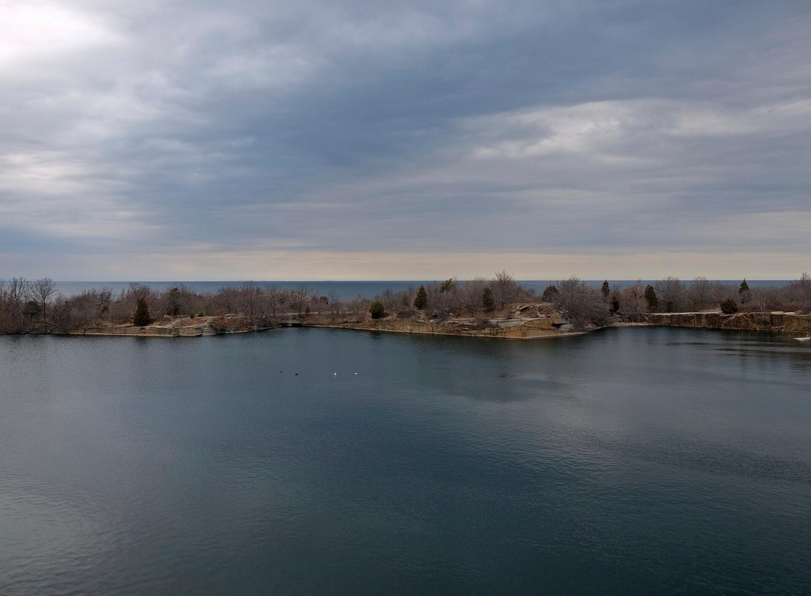 The flooded Babson Farm granite quarry at Halibut Point State Park, Rockport, Essex County, Massachusetts, with the Atlantic on the horizon