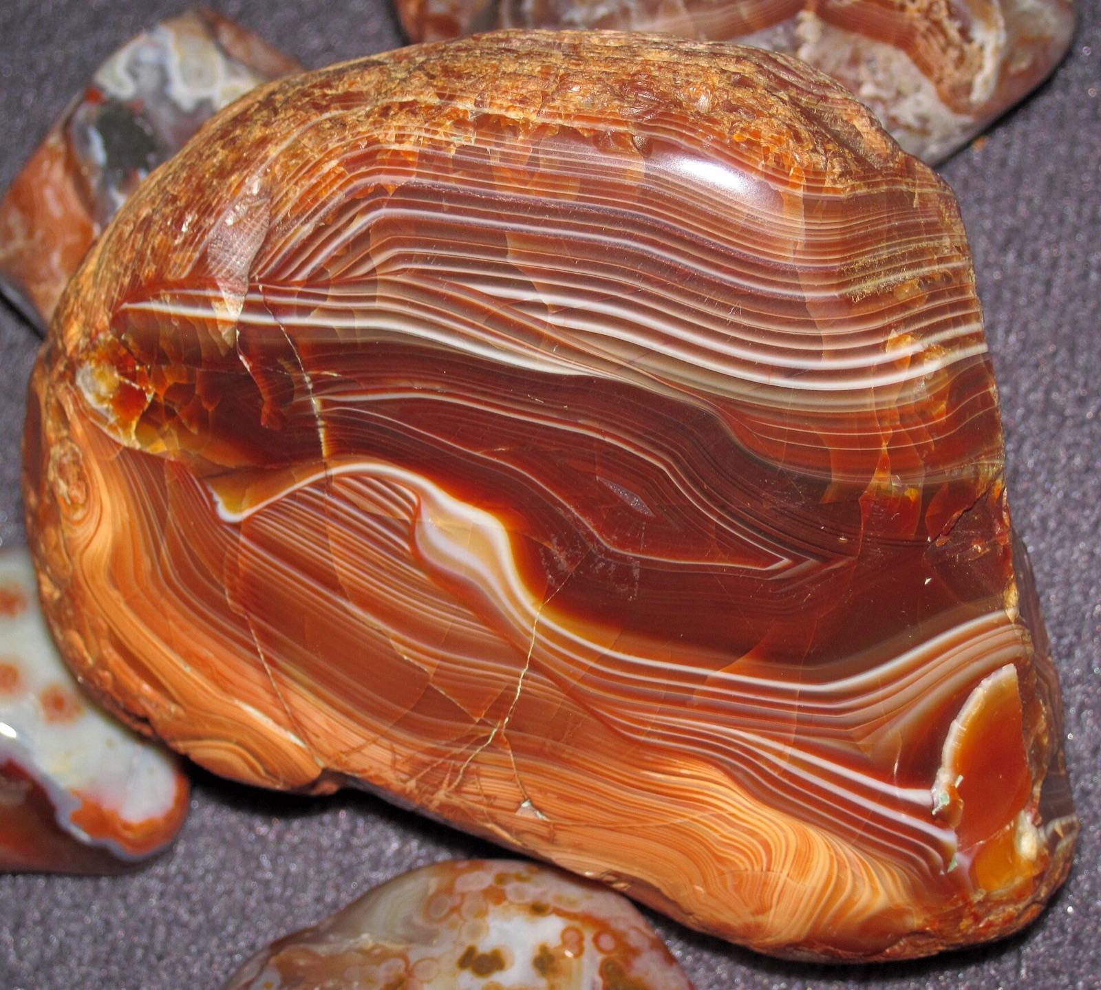 A polished Lake Superior agate with banded fortification structure, the same tumble rounded ice transported agate documented from Grundy County glacial drift and stream gravels.