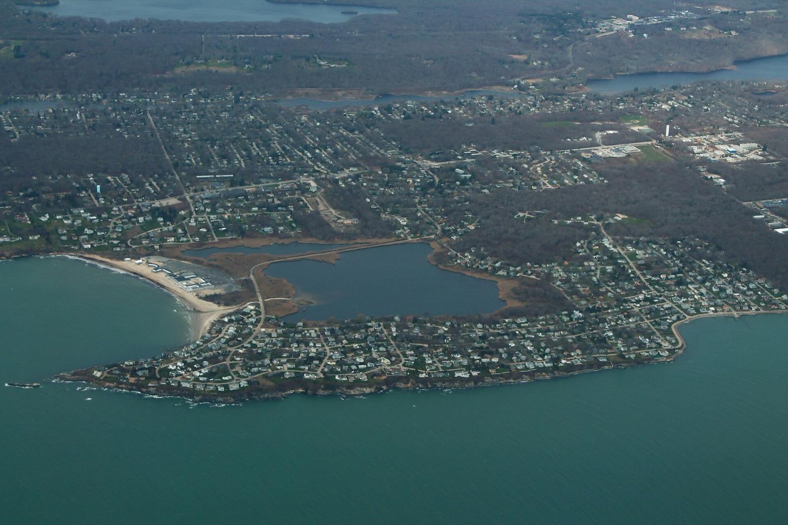 Aerial view of the Bonnet Shores peninsula and its rocky coast in Narragansett, Rhode Island, where pegmatite outcrops carry beryl and quartz.
