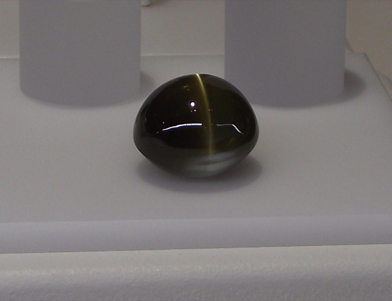 Cat's eye chrysoberyl cabochon with a sharp bright line across the dome, San Diego Natural History Museum