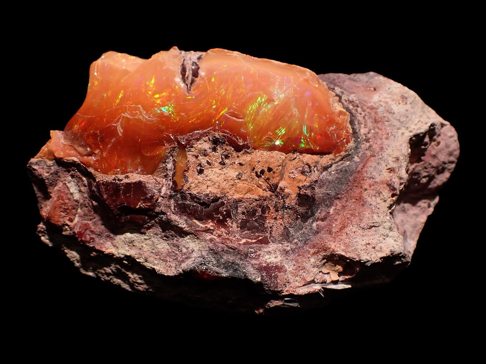 Precious Mexican fire opal with play of color in pink rhyolite matrix