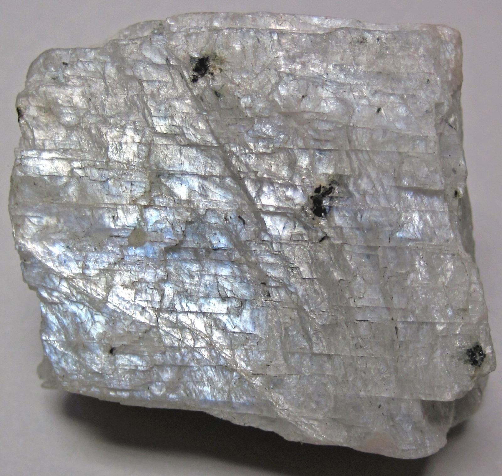 Rough moonstone feldspar with a bluish-white shimmer on its cleavage faces