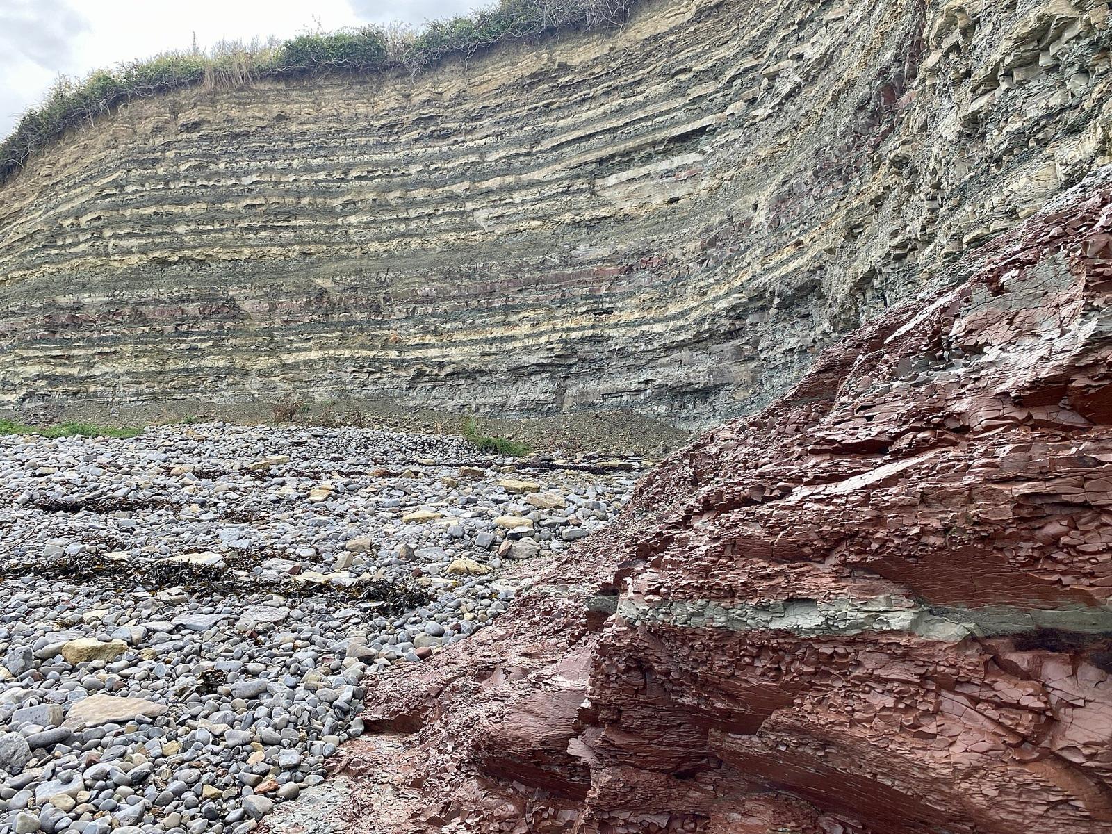 Outcrop of red and green mudstone beds on a beach
