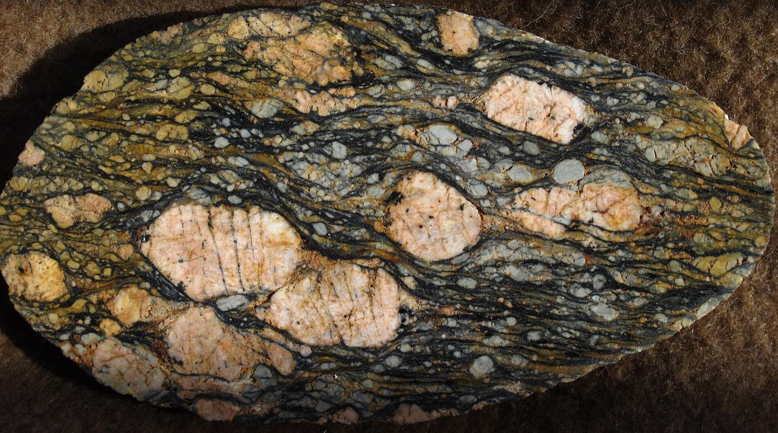 Polished augen mylonite with pink feldspar porphyroclasts in a sheared matrix