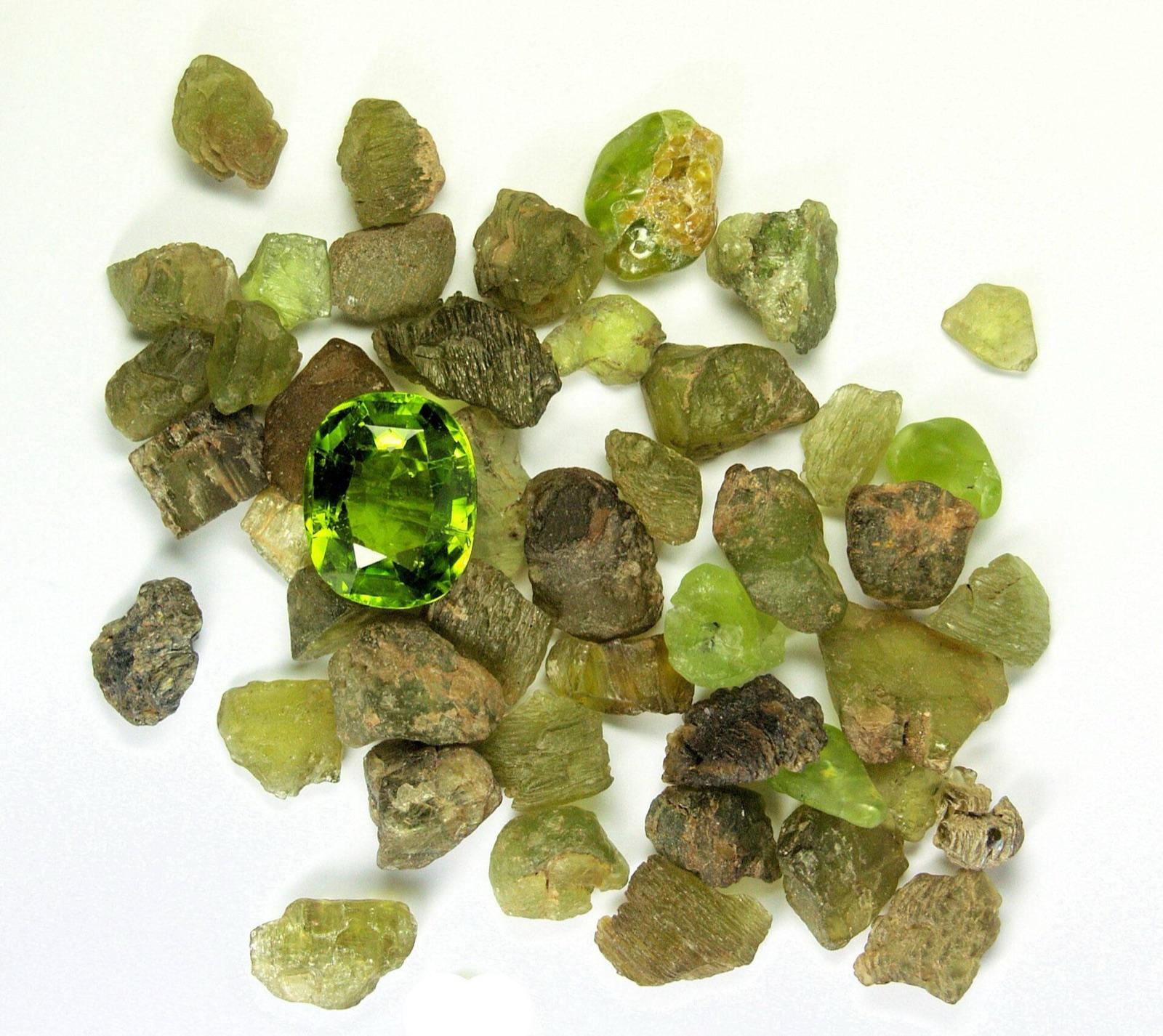 Rough peridot pebbles around a cut peridot gem